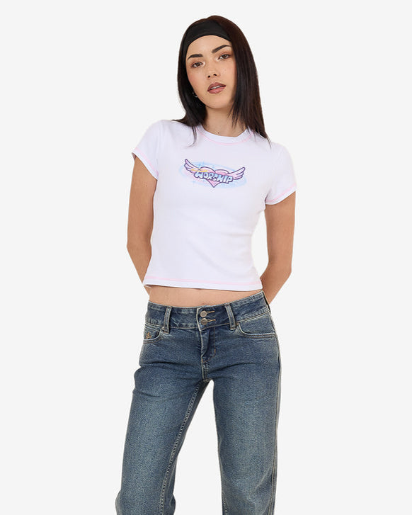 White Worship graphic crop tee with pink trim styled with blue jeans