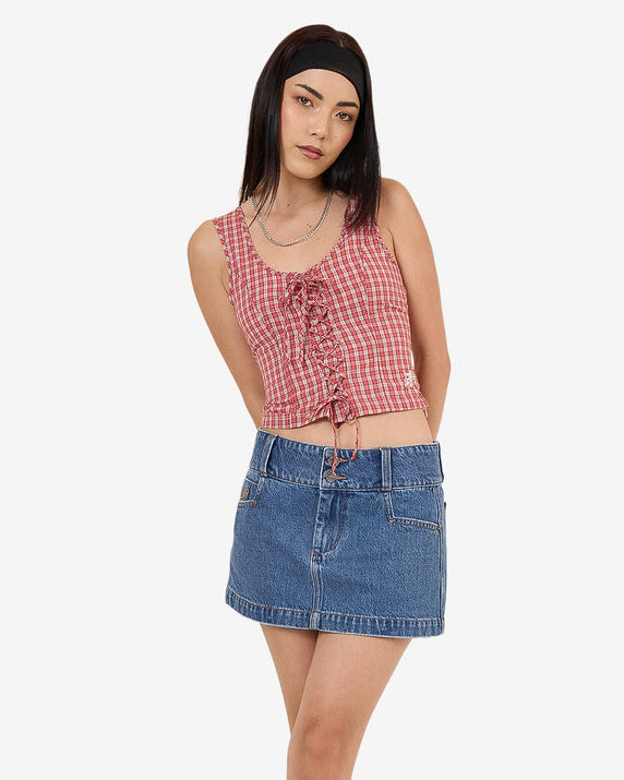 Model wearing red check lace-up sleeveless top with scoop neck and cropped fit