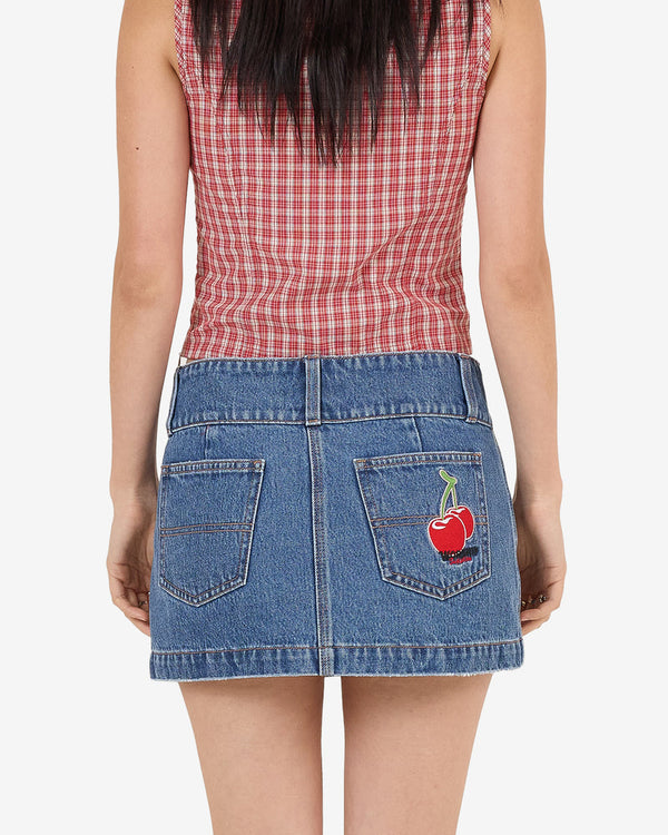 Back view of denim mini skirt with embroidered cherry on pocket, paired with red check lace-up top