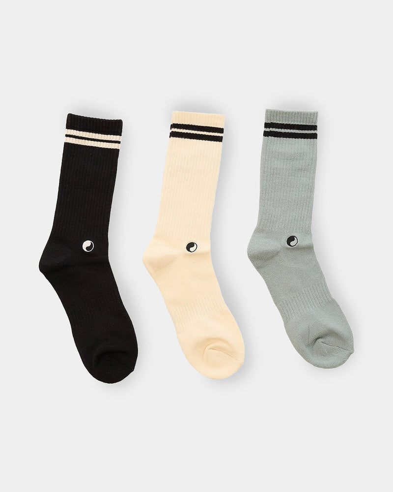 Back view of three-pack crew socks in black, cream and sage featuring Good Morning Tapes eye logo above heel.