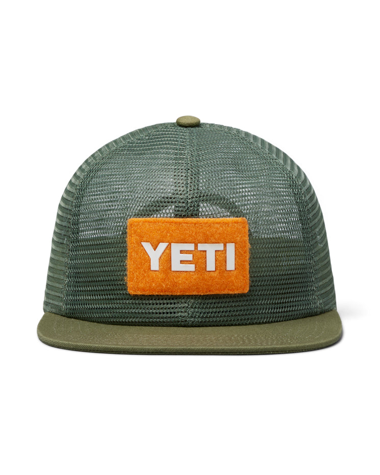 Front view of an olive green YETI cap with a bright orange patch featuring the YETI logo and a breathable mesh design.