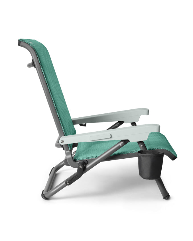 Side view of teal YETI Lowlands chair with reclining frame and built-in cup holder.