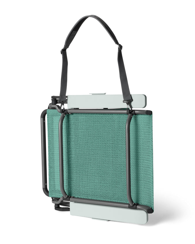 Folded teal YETI chair with shoulder strap for easy carrying and compact storage.