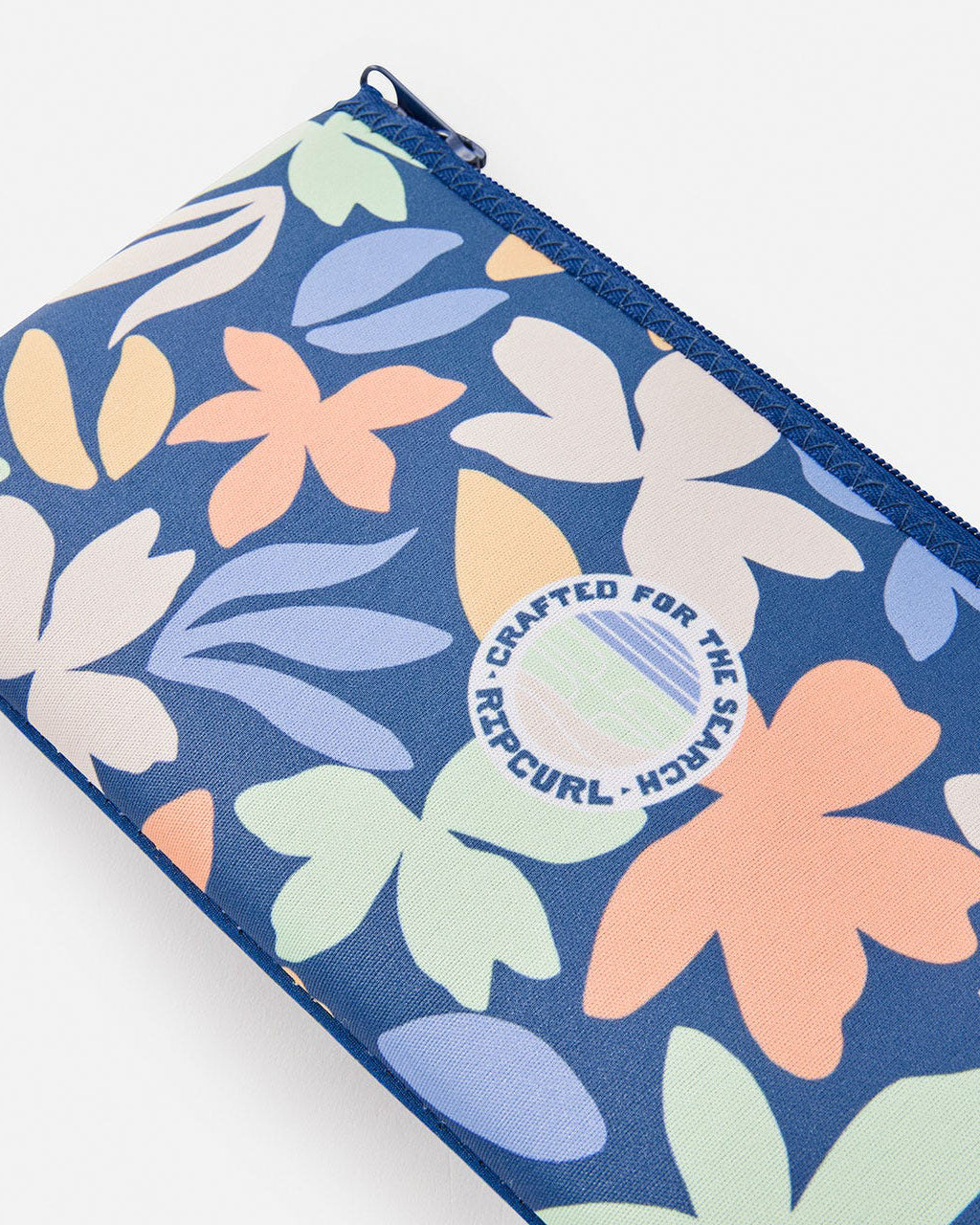 Close-up view of a Rip Curl pencil case showcasing its vibrant floral pattern, circular logo detail, and durable zipper closure.