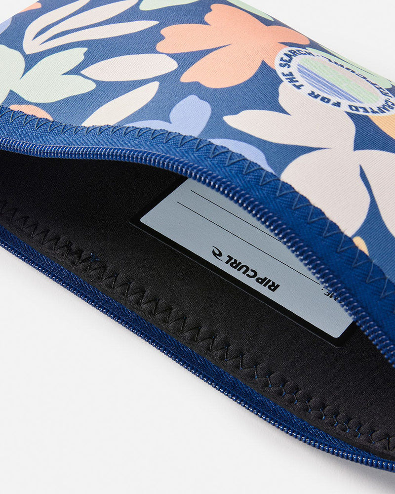 Open Rip Curl pencil case showing a vibrant floral exterior, stitched edges, and an interior name tag for personalization.